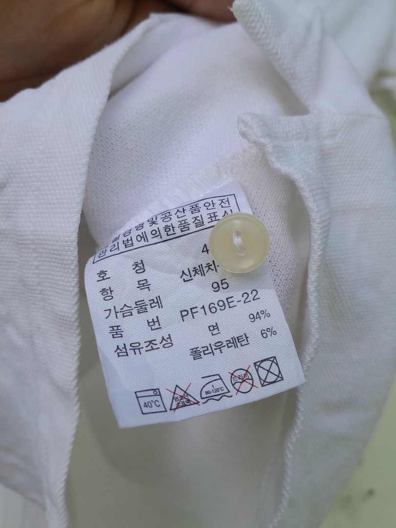 Lacoste White Polo Shirt Size 40 (Category: Shirts) located in Bayabas. Submitted by justhriftwithme (Listing ID 1468068103, Image 3). Description: - Authentic Lacoste polo shirt in crisp white - Classic pique cotton blend with 6% polyurethane for comfort (94% cotton, 6% polyurethane) - Size: 40 / 95 - Features a button-up placket with genuine mother-of-pearl buttons - Iconic green embroidered crocodile logo on the chest.