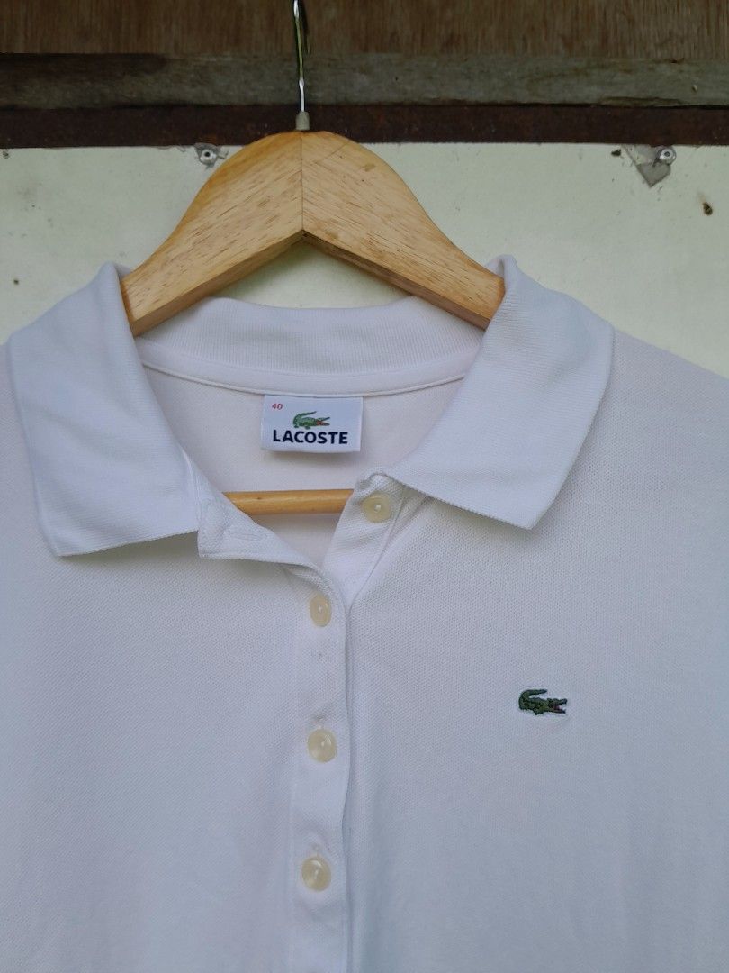 Lacoste White Polo Shirt Size 40 (Category: Shirts) located in Bayabas. Submitted by justhriftwithme (Listing ID 1468068103, Image 2). Description: - Authentic Lacoste polo shirt in crisp white - Classic pique cotton blend with 6% polyurethane for comfort (94% cotton, 6% polyurethane) - Size: 40 / 95 - Features a button-up placket with genuine mother-of-pearl buttons - Iconic green embroidered crocodile logo on the chest.