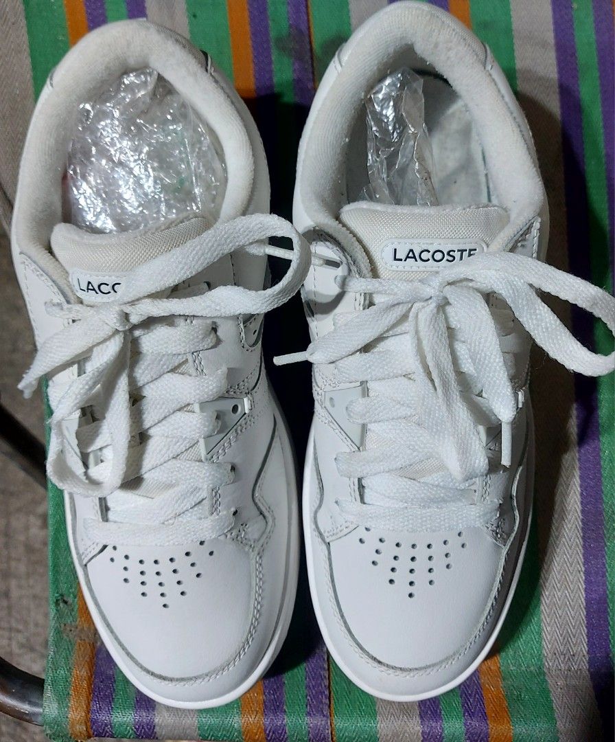 Lacoste White Sneakers (Category: Sneakers) located in Nabunturan. Submitted by creep012181 (Listing ID 1468209382, Image 1). Description: White Lacoste sneakers with classic crocodile logo on the side. Lace-up closure, chunky rubber sole, and perforated details on the toe and side panels. Clean white leather upper with matching laces. Comfortable everyday trainers with distinct branding on the tongue and heel area..