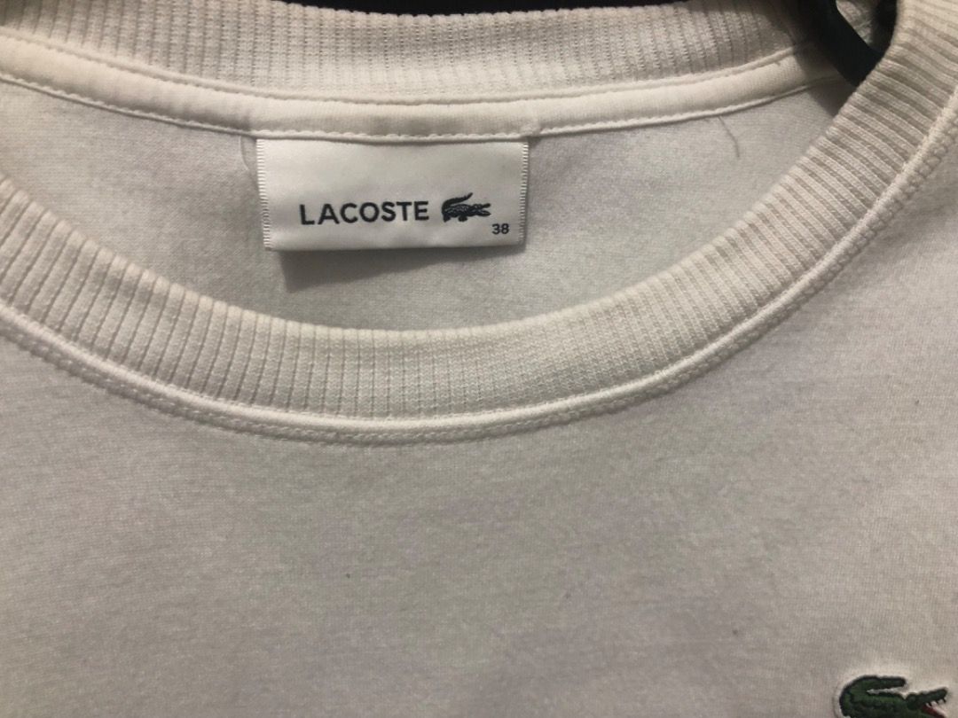 Lacoste White T-shirt Size 38 (Category: Shirts) located in Manila. Submitted by kissa.1890 (Listing ID 1468074204, Image 2). Description: - Brand: Lacoste - Color: Clean White - Size: 38 (Tag attached) - Material: 100% Cotton - Design: Classic crew neck with ribbed trim and short sleeves - Logos & Details: Iconic green embroidered crocodile on the chest and stylish graphic text embroidery on the left sleeve - Condition: Excellent, clean fabric t