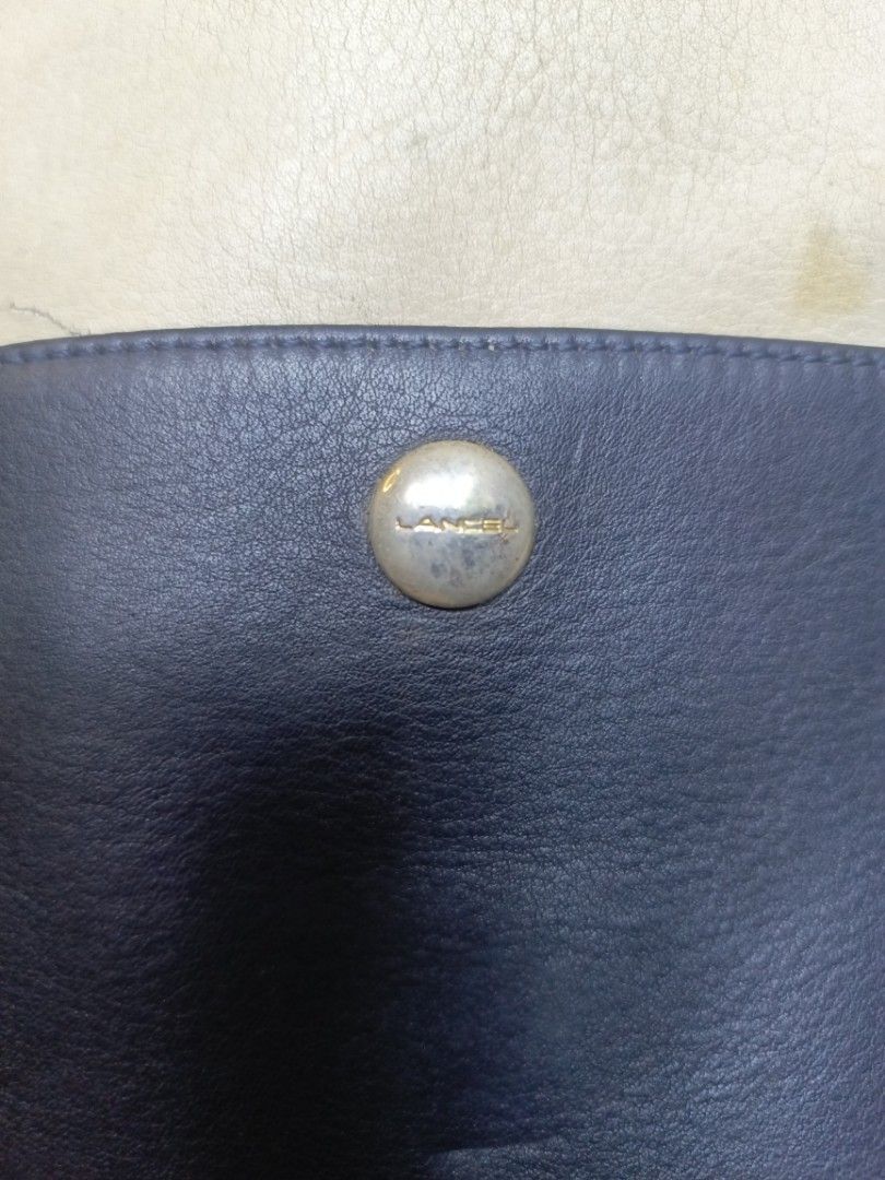 Lancel Leather Shoulder Bag Navy Cream (Category: Shoulder Bags) located in Manila. Submitted by del_thrifts03 (Listing ID 1468109165, Image 3). Description: - Authentic Lancel shoulder bag in a stylish navy blue and cream leather two-tone design - Features eye-catching gold-tone metal snaps on the front pocket - Equipped with a long strap for comfortable shoulder wear - Clean, structured shape with neat side seams - Practical, good everyday size