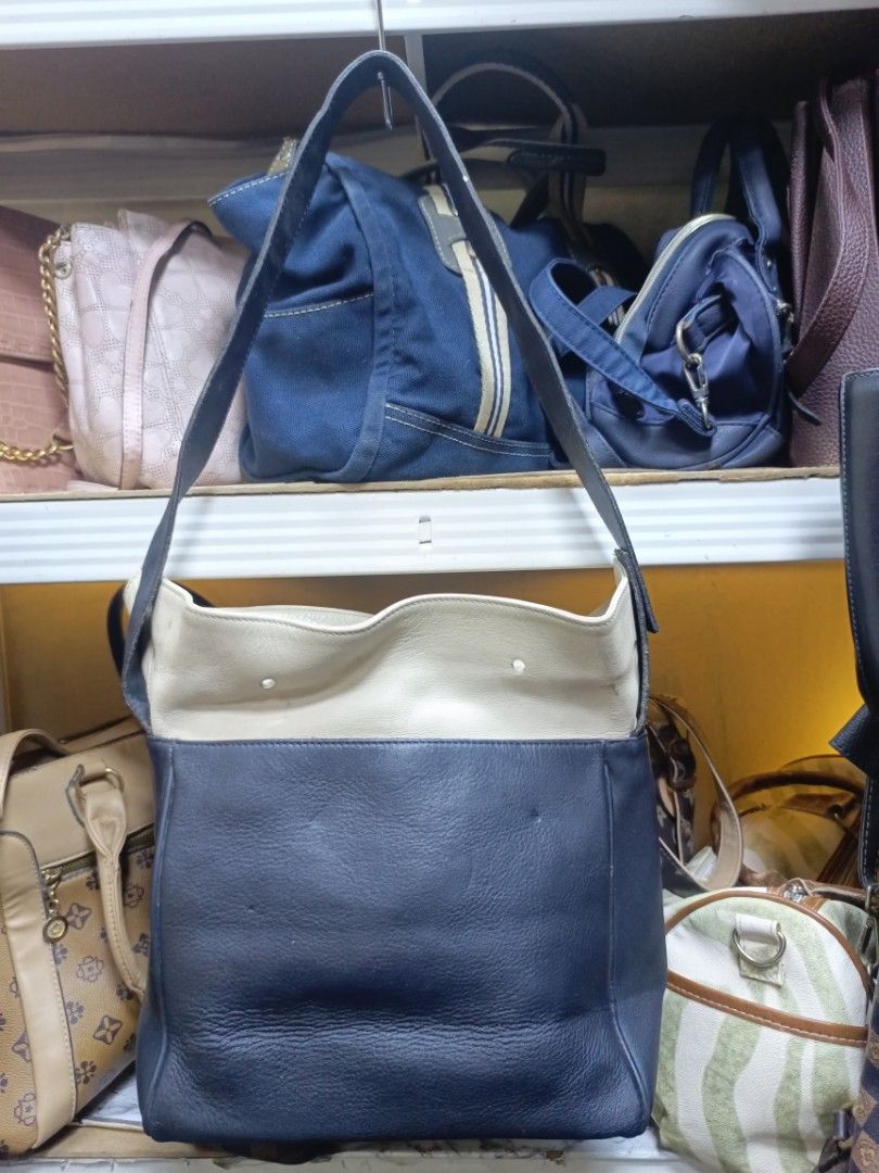 Lancel Leather Shoulder Bag Navy Cream (Category: Shoulder Bags) located in Manila. Submitted by del_thrifts03 (Listing ID 1468109165, Image 2). Description: - Authentic Lancel shoulder bag in a stylish navy blue and cream leather two-tone design - Features eye-catching gold-tone metal snaps on the front pocket - Equipped with a long strap for comfortable shoulder wear - Clean, structured shape with neat side seams - Practical, good everyday size