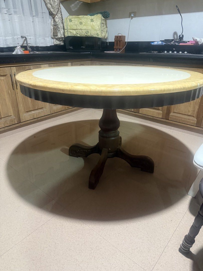 Large Round Wooden Dining Table with Pedestal Base (Category: Tables & Sets) located in Bulacan. Submitted by maryann1411 (Listing ID 1468139416, Image 1). Description: - Large round dining table with heavy, solid construction - Sturdy wooden pedestal base featuring carved feet - White center top with a decorative patterned yellow rim and dark edge trim - Comfortably seats several chairs, ideal for family dinners or kitchens - Shows normal surfac