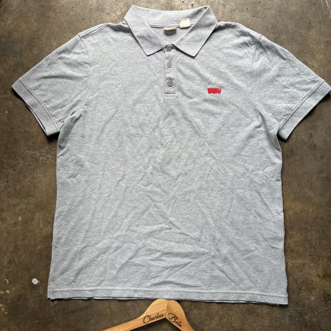 Levi's Grey Polo Shirt (Category: Tshirts & Polo Shirts ) located in Davao. Submitted by charlesole52665 (Listing ID 1468096927, Image 1). Description: - Brand: Levi's - Color: Grey - Size: XL on tag - Width: 23 inch - Length: 28 inch - Material: Classic cotton knit - Logo: Embroidered red batwing logo on left chest - Details: Three-button placket with branded buttons, ribbed cuffs, and iconic red tab on the side hem - Condition: Excellent / Pre-