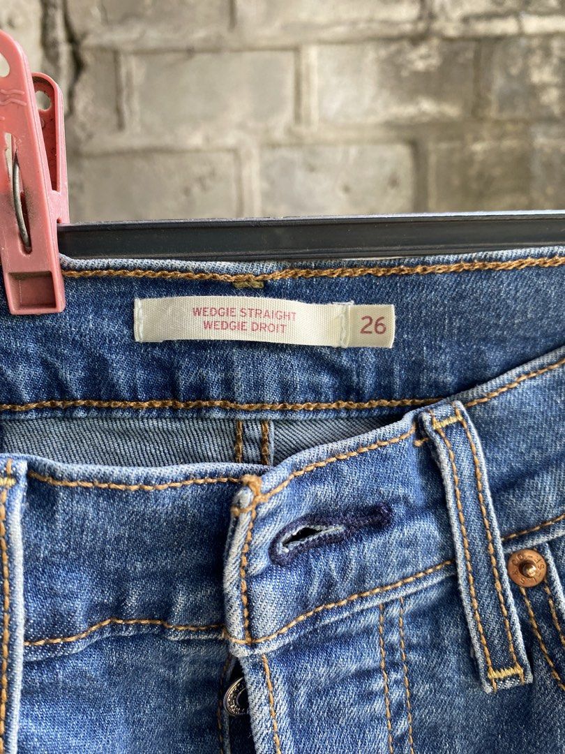 Levi's Wedgie Straight Jeans Size 26 (Category: Jeans) located in Pulupandan. Submitted by pointyspoon (Listing ID 1468080923, Image 2). Description: - Brand: Levi's - Style: Wedgie Straight jeans - Color/Wash: Medium blue with front thigh fading - Size: Tag size 26 Tape Measure: 26 in waist 26 in inseam 36 in outseam 14 in leg opening - Fit: High-waisted and straight leg - Details: Button fly closure and classic five-pocket styling.