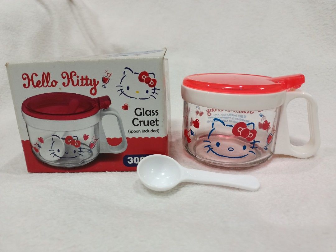 License Hello Kitty Glass Condiment Container with Spoon 300ml (Category: Food Organization & Storage) located in Manila. Submitted by jollynest24 (Listing ID 1468223122, Image 1). Description: - License Hello Kitty Glass Condiment Container ( Brand New) - Capacity: 300ml, ideal for kitchen condiments or table use - Features adorable Kitty graphics and cherry motifs all around - Clear glass body paired with a charming red and white lid and handle