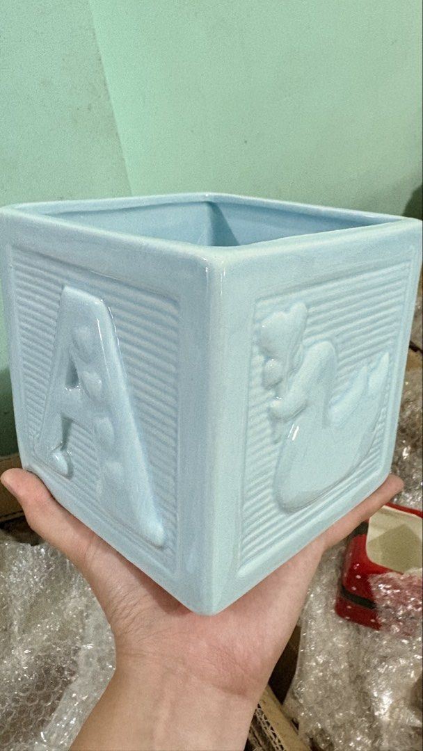 Light Blue Ceramic Baby Block planter/holder (Category: Other Home Decor) located in Quezon City. Submitted by ar.sulit.finds (Listing ID 1468257928, Image 2). Description: - Material: High-quality ceramic with a glossy finish - Design: Light blue block planter with a raised letter B on one side and a teddy bear on the other - Texture: Stylish ribbed borders with an open top and hollow interior - Versatility: Ideal as a small plant pot, succulent