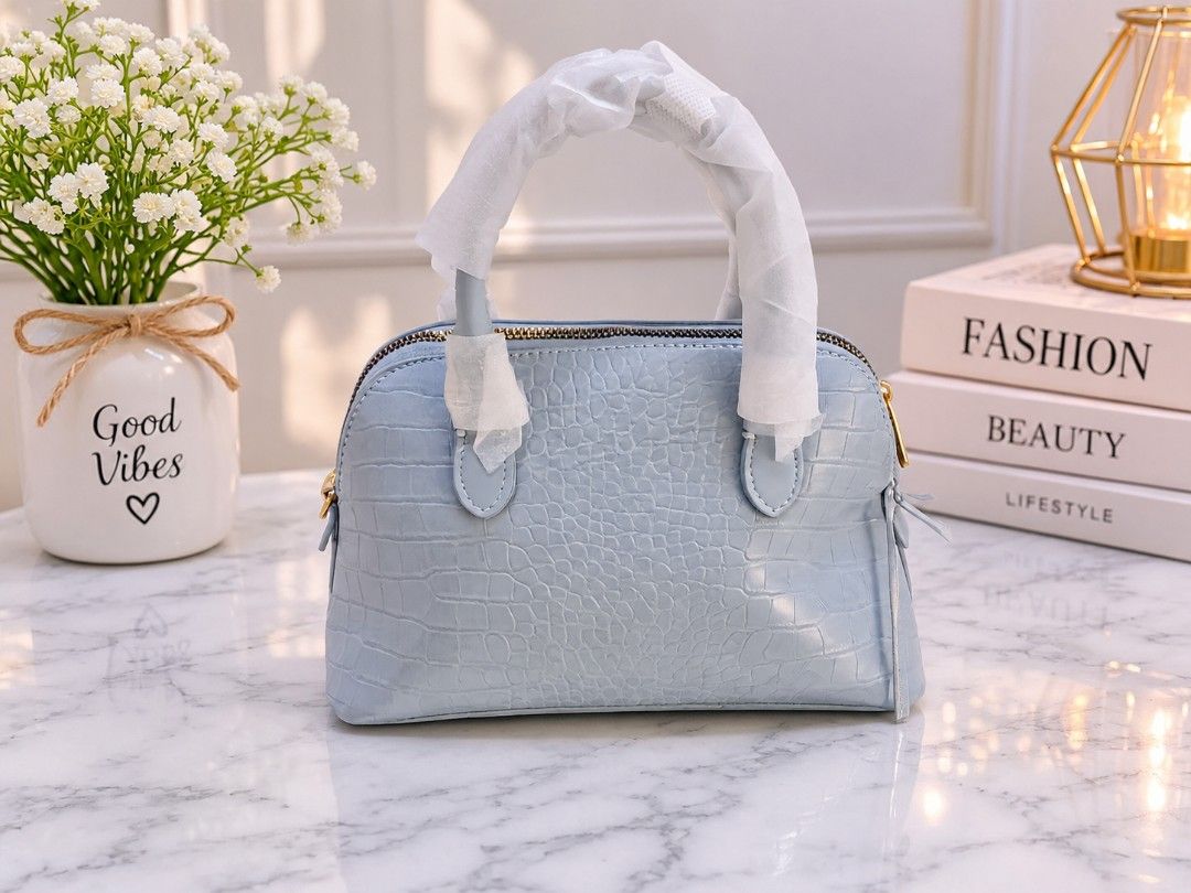 Light Blue Croc-Embossed Dome Handbag (Category: Shoulder Bags) located in Quezon City. Submitted by iza_collection07 (Listing ID 1468245793, Image 2). Description: - Color & Texture: Light blue faux leather with all-over croc-embossed design - Style: Chic dome shape with elegant gold-tone hardware - Condition: Brand new, handles still wrapped in protective paper, 100% scratch and scuff-free - Structure: Clean, sturdy base that holds its shape we