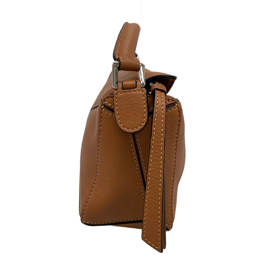 Loewe Mini Puzzle Bag Tan (Category: Shoulder Bags) located in Las Pinas. Submitted by daisuki_japan_luxury_by_reiko (Listing ID 1468077004, Image 2). Description: Condition Notes [Exterior] Main opening: Corner scuffs / Hardware deterioration ; Handle: Corner scuffs / Dirt / Stains ; Bottom: Corner scuffs ; Overall: Loss of shape. [Interior] Overall: Scratches (some pilling) / Dirt. [Special Notes] Main body: Accessories (slight dirt on the dust