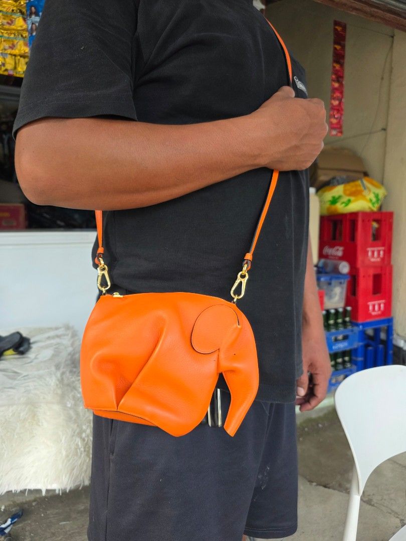 Loewe Orange Elephant Crossbody Bag (Category: Cross-body Bags) located in Lemery. Submitted by venus23 (Listing ID 1468221423, Image 1). Description: - Loewe elephant crossbody bag in a vibrant bright orange textured leather - Features iconic elephant design complete with ear and trunk details - Elegant gold-tone hardware with a secure zipper closure - Adjustable leather shoulder strap fitted with Loewe-stamped gold clasps - Clean pebbled leathe