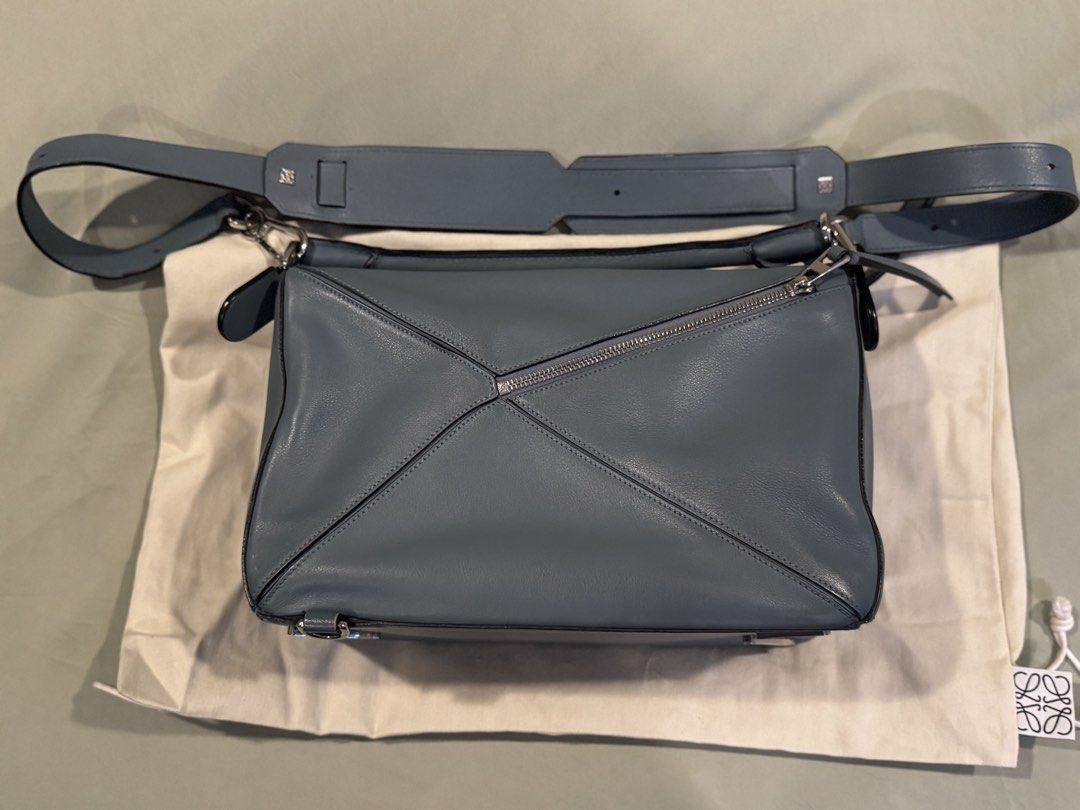 Loewe Puzzle Bag Blue Leather (authentic) (Category: Luxury Bags & Wallets) located in Pasig City. Submitted by sharonjab (Listing ID 1468143337, Image 2). Description: - Authentic Loewe Puzzle Bag in a gorgeous blue shade - Crafted from premium calfskin leather with sleek silver-tone hardware - Distinct geometric panel construction for a modern look - Practical top handle and removable shoulder strap for versatile styling - Clean cream textile i