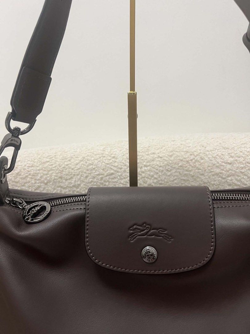 Longchamp Brown Leather Shoulder Bag (Category: Luxury Bags & Wallets) located in Abulug. Submitted by jamiecammie (Listing ID 1468142213, Image 3). Description: - Authentic Longchamp handbag in dark brown leather - Adjustable shoulder strap for custom fit - Secure flap closure with embossed horse logo snap button - Top zip opening for main compartment safety - Interior lined with signature branded jacquard fabric - Includes convenient inner slip