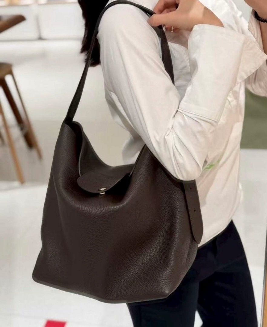 Longchamp Cadence L Shoulder Bag (Category: Shoulder Bags) located in Paoay. Submitted by rvf1230 (Listing ID 1468143476, Image 1). Description: - Brand: Longchamp - Material: Rich dark brown grained leather - Hardware: Gold-tone studs - Strap: Adjustable shoulder strap - Closure: Front flap with snap button and embossed horse logo - Interior: Unlined with an open side pocket - Inclusions: Protective dust bag and store tag attached - Condition: B