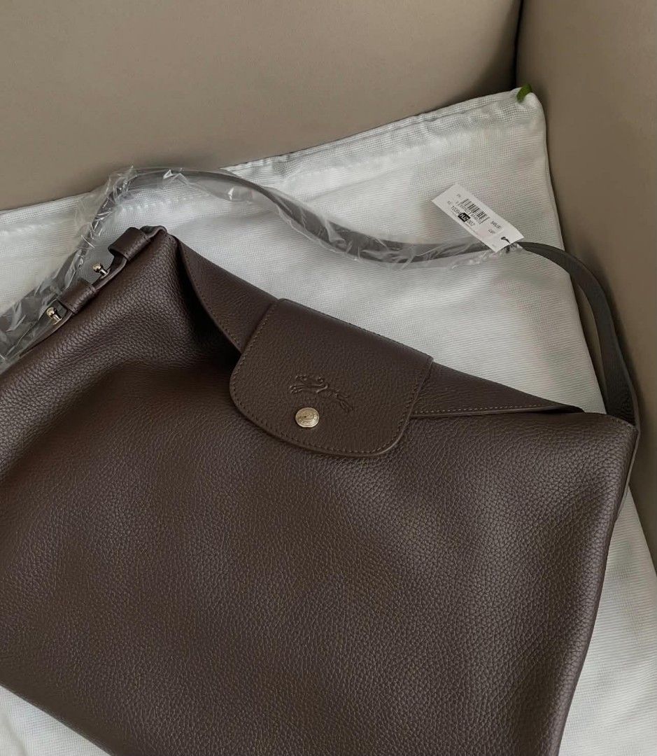 Longchamp Cadence L Shoulder Bag (Category: Shoulder Bags) located in Paoay. Submitted by rvf1230 (Listing ID 1468143476, Image 2). Description: - Brand: Longchamp - Material: Rich dark brown grained leather - Hardware: Gold-tone studs - Strap: Adjustable shoulder strap - Closure: Front flap with snap button and embossed horse logo - Interior: Unlined with an open side pocket - Inclusions: Protective dust bag and store tag attached - Condition: B