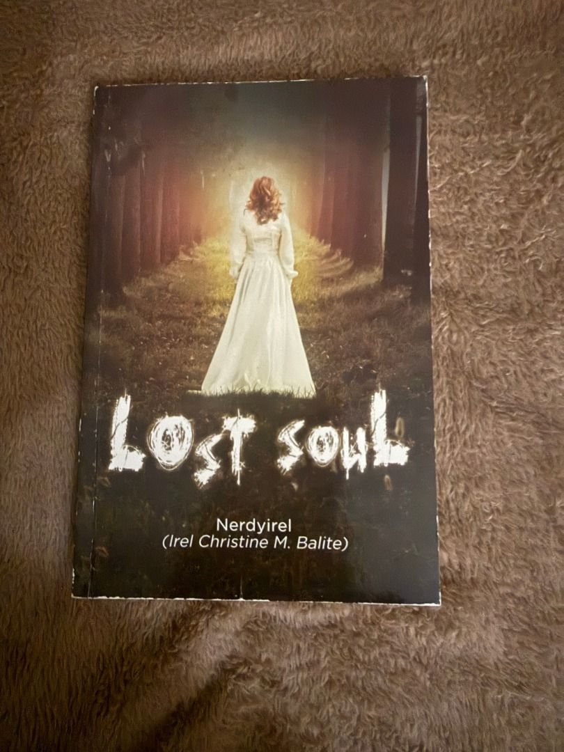 Lost Soul by Nerdyirel (Category: Storybooks) located in Manila. Submitted by bellevuebooks (Listing ID 1468255068, Image 1). Description: Paperback book titled Lost Soul. Written by Nerdyirel, also known as Irel Christine M. Balite. Cover image shows a person in a white dress walking down a wooded path towards bright light. Spine shows slight wear at the edge. Clean pages inside..