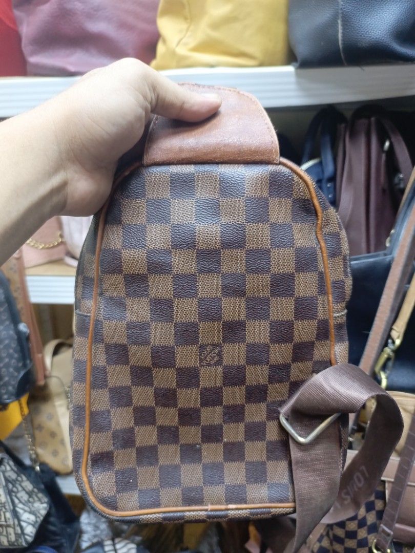Louis Vuitton Damier Ebene Sling Bag (Category: Luxury Bags & Wallets) located in Manila. Submitted by del_thrifts03 (Listing ID 1468111132, Image 3). Description: - Stylish brown checkerboard pattern - Premium tan leather accent patch on front pocket and top handle - Comfortable branded fabric strap with adjustable metal buckle - Secure zip closure with engraved metal puller - Compact size, perfect for daily wear and essentials.