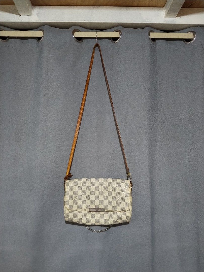 Louis Vuitton Damier Favorite Sling Bag (Category: Luxury Bags & Wallets) located in Pasig City. Submitted by loveforlux_2025 (Listing ID 1468283209, Image 1). Description: - Louis Vuitton crossbody bag - Classic Damier Azur white and blue checkerboard canvas - Premium tan leather strap, trim, and brown leather sides - Front flap with metal closure plate and trendy dangling gold-toned chain - Functional back design with dual snap buttons and pock