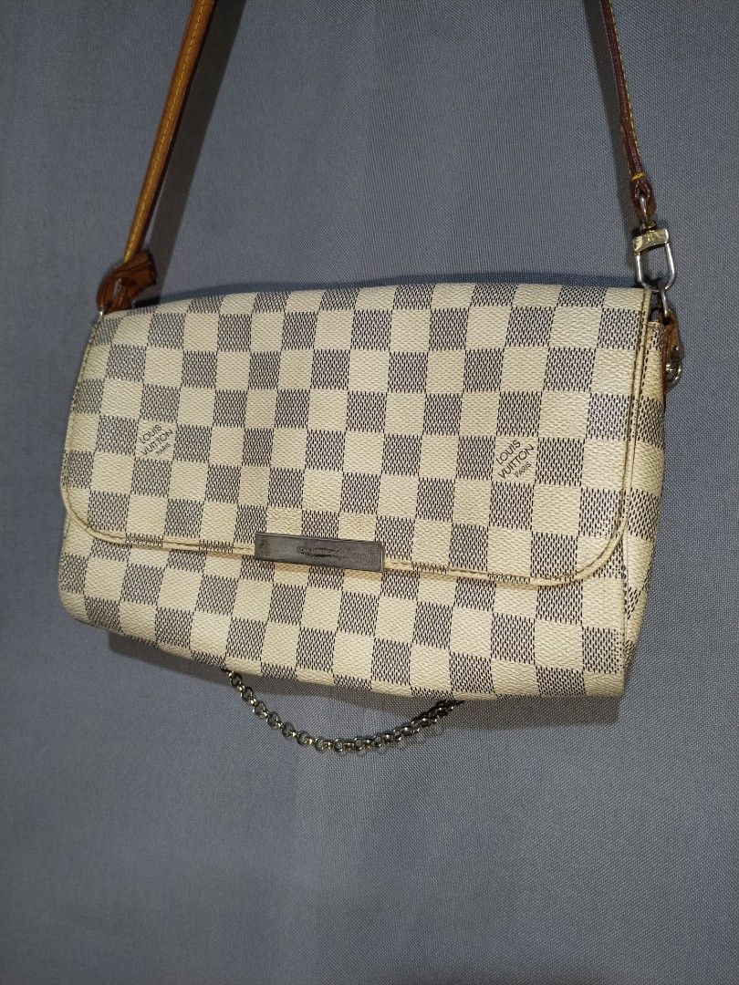 Louis Vuitton Damier Favorite Sling Bag (Category: Luxury Bags & Wallets) located in Pasig City. Submitted by loveforlux_2025 (Listing ID 1468283209, Image 2). Description: - Louis Vuitton crossbody bag - Classic Damier Azur white and blue checkerboard canvas - Premium tan leather strap, trim, and brown leather sides - Front flap with metal closure plate and trendy dangling gold-toned chain - Functional back design with dual snap buttons and pock
