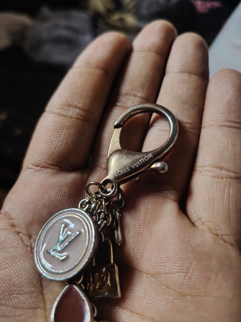 Louis Vuitton Monogram Flower Bag Charm Keychain (Category: Luxury Bags & Wallets) located in Baguio. Submitted by angeloshoppebaguio2600 (Listing ID 1468136591, Image 2). Description: - Louis Vuitton keychain with multiple charms - Includes padlock, key, pink & brown enamel monogram flowers, and LV logo circle charm - Features gold-tone hardware with engraved LV lettering on the clasp - Condition: Shows normal surface tarnishing and wear on meta