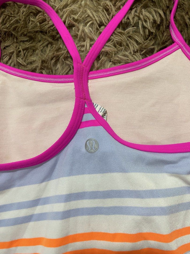 Lululemon Athletic Striped Tank Top Size 8 (Category: Sleeveless) located in Cagayan de Oro. Submitted by sepamorash53558 (Listing ID 1468264301, Image 3). Description: - Brand: Lululemon - Size: 8 (tag attached) - Design: Multi-color striped pattern with lavender blue base and bright pink straps - Features: Racerback style with built-in shelf bra lining and signature silver logo on back hem - Material: Premium polyester and nylon blend - Care: M