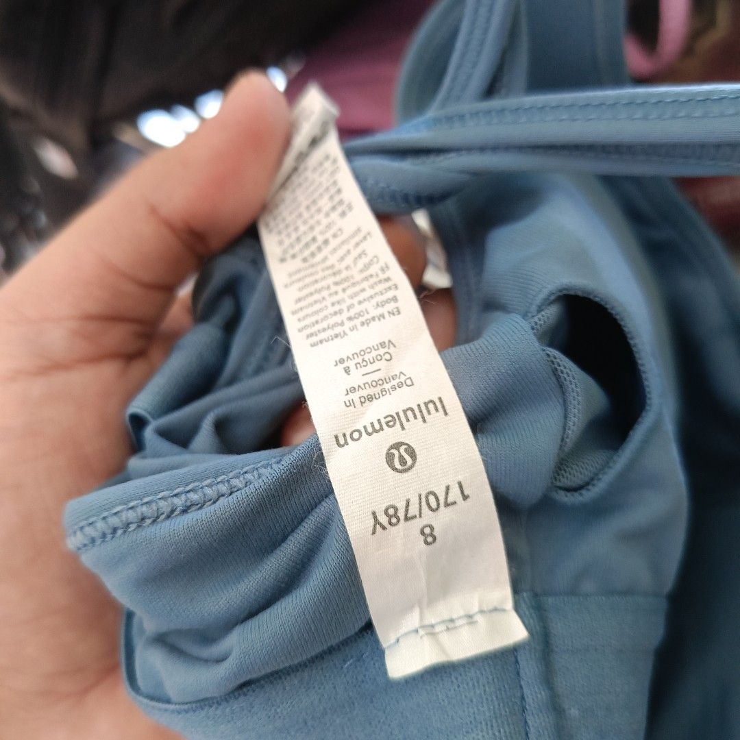 Lululemon Blue Strappy Back Tank Top Size 8 (Category: Activewear) located in San Jose del Monte. Submitted by qu4litees (Listing ID 1468071009, Image 3). Description: - Brand: Lululemon - Color: Dusty Blue - Size: 8 (tag attached) - Features: Built-in bra lining with removable cup slots, strappy criss-cross back design, and signature reflective logo - Material: Smooth and stretchy athletic fabric (Made in Vietnam).