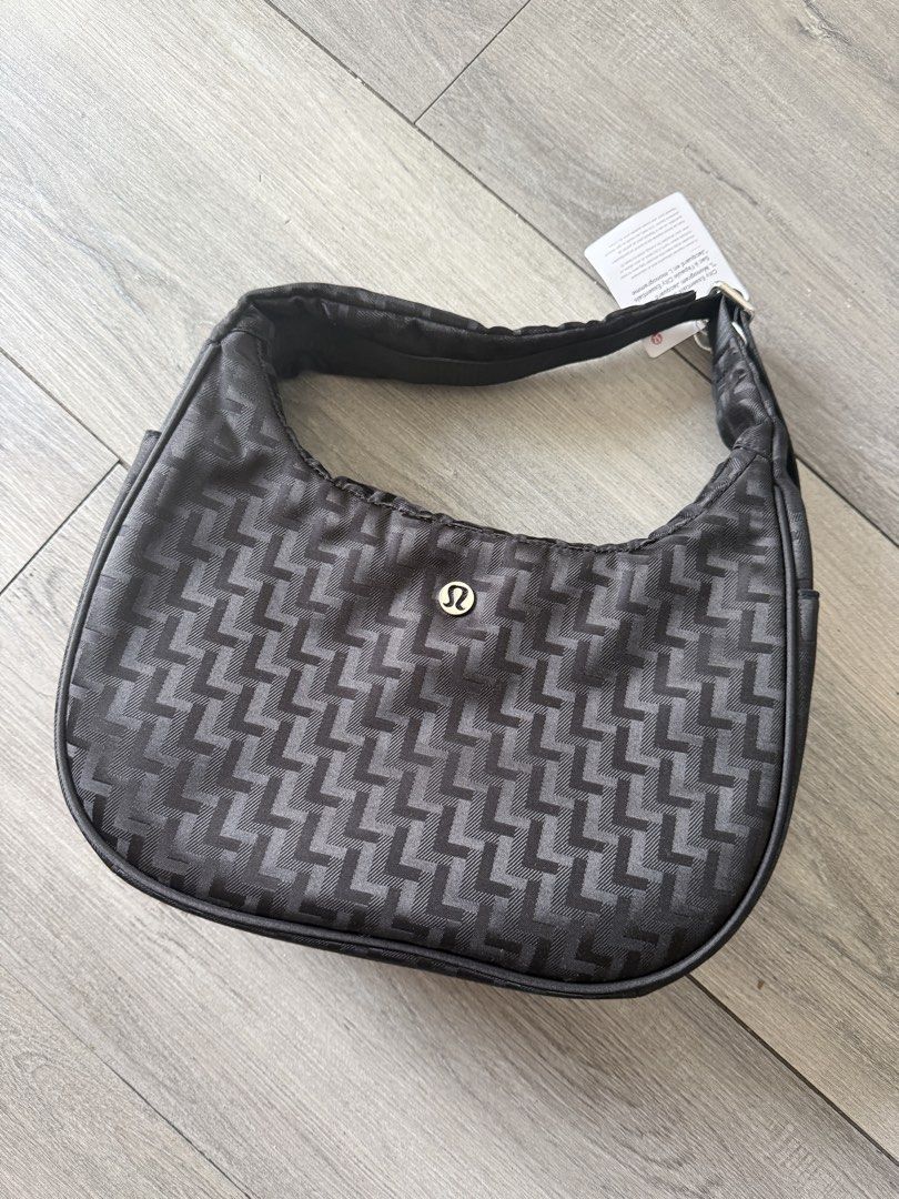 Lululemon City Essentials Shoulder Bag Monogram Jacquard Black (Category: Shoulder Bags) located in Cainta. Submitted by mrsohhmj (Listing ID 1468076082, Image 1). Description: - Brand: Lululemon - Style: City Essentials Shoulder Bag - Color/Pattern: Black with all-over 'L' monogram jacquard - Condition: Brand new with original store tag attached - Features: Adjustable shoulder strap with metal buckle, exterior back zip pocket, top zip closure wi