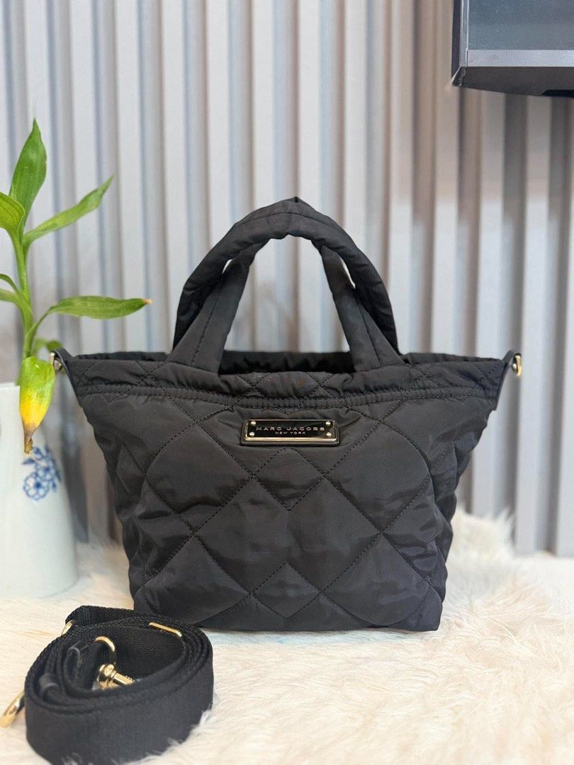 Marc Jacobs Black Quilted Nylon Tote Bag with Strap (Category: Tote Bags) located in Manila. Submitted by angel.valle (Listing ID 1468169427, Image 1). Description: - Brand: Marc Jacobs - Style: Quilted nylon tote bag in classic black - Hardware: Gold-tone with front metal logo plaque - Straps: Double padded top handles + adjustable, detachable shoulder strap with gold clasps - Closure: Secure zip top - Design: Chic quilted diamond pattern throug