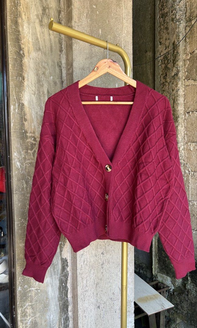 Maroon Knitted Cardigan V-Neck Button-Up Sweater (Category: Coats, Jackets and Outerwear) located in Cagayan de Oro. Submitted by elviecup (Listing ID 1468084937, Image 1). Description: Deep maroon knit cardigan with diamond texture pattern all over. V-neck cut with three tortoise-style buttons down the front. Ribbed hem and cuffs. Long sleeves. Soft material, warm and cozy for layering over tops. Great piece for cooler weather or casual outfits.