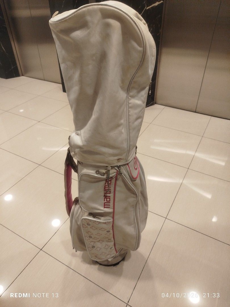 Maruman Golf Bag White Pink (Category: Golf) located in Taguig. Submitted by steve_doms (Listing ID 1468121759, Image 3). Description: - Brand: Maruman - Color: White with stylish pink accents - Storage: Multiple side pockets for all your gear - Protection: Includes upper cover with zipper closure - Stability: Structured base keeps the bag standing upright - Condition: Minor scuffs and marks on the white surface from previous use.