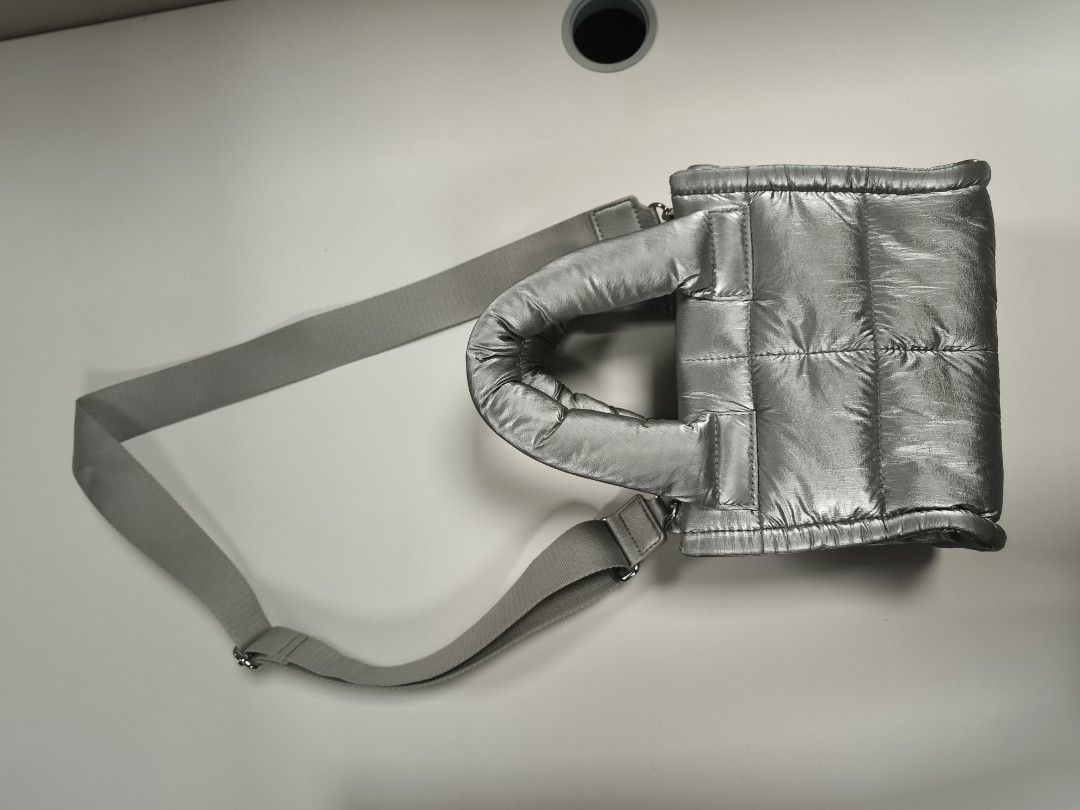 Metallic Silver Puffer Tote Bag with Crossbody Strap (Category: Tote Bags) located in Quezon City. Submitted by jdonor (Listing ID 1468095556, Image 2). Description: GU puff mini shoulder bag - Metallic silver quilted puffer tote bag - Dual structured top handles and adjustable webbed crossbody strap with silver hardware - Secure magnetic snap top closure - Clean interior lining with spacious open compartments - Lightweight and comfortable padded