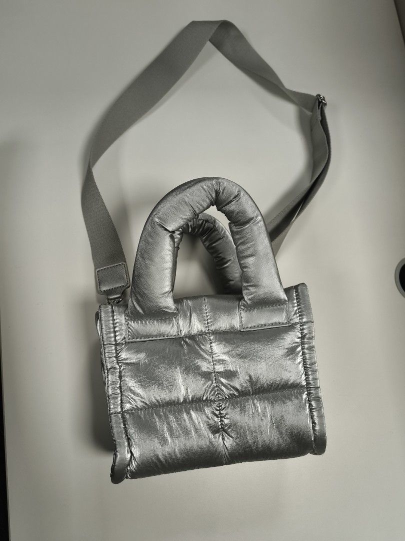 Metallic Silver Puffer Tote Bag with Crossbody Strap (Category: Tote Bags) located in Quezon City. Submitted by jdonor (Listing ID 1468095556, Image 1). Description: GU puff mini shoulder bag - Metallic silver quilted puffer tote bag - Dual structured top handles and adjustable webbed crossbody strap with silver hardware - Secure magnetic snap top closure - Clean interior lining with spacious open compartments - Lightweight and comfortable padded