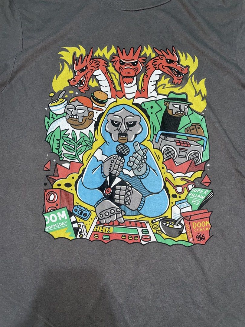 MF Doom Graphic Print T-Shirt Grey (Category: Tshirts & Polo Shirts ) located in Manila. Submitted by joshua_guimeroy. (Listing ID 1468213925, Image 2). Description: - Color: Grey - Design: Colorful MF Doom hip hop graphic print on front - Fit: Standard fit with crew neck style - Condition: Clean fabric, vibrant graphic with no cracking - Perfect for: Underground rap fans and streetwear enthusiasts - Shipping or meet-ups available across the Phil
