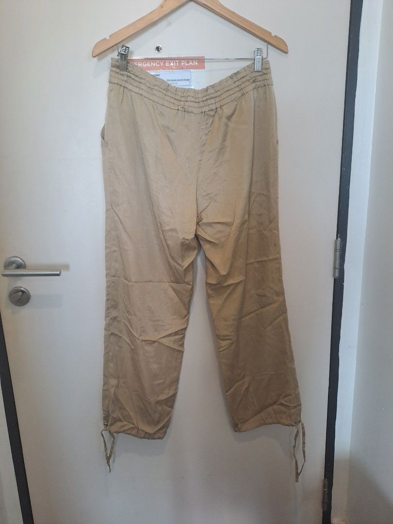 MICHAEL KORS BEIGE PANTS (Category: Other Bottoms) located in Manila. Submitted by joanbalde39643 (Listing ID 1468098068, Image 2). Description: The image shows a pair of MICHAEL KORS khaki or beige relaxed-fit cargo or parachute-style trousers with an elasticized waistband and drawstring hems..