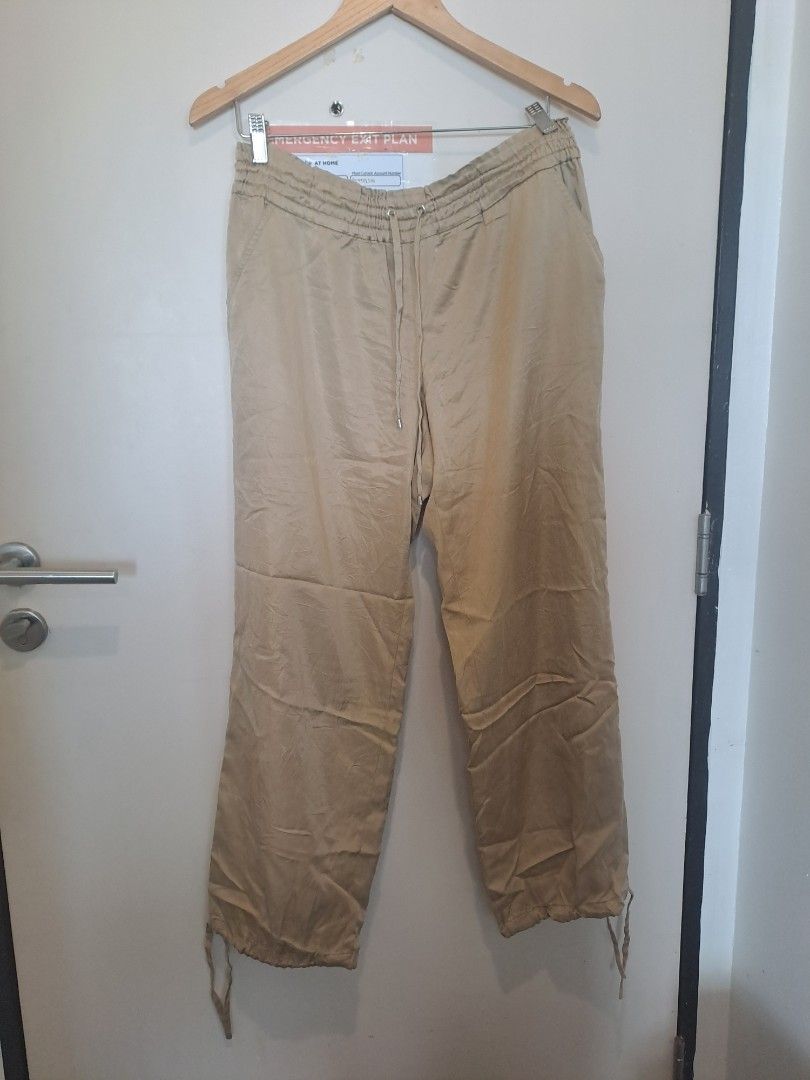 MICHAEL KORS BEIGE PANTS (Category: Other Bottoms) located in Manila. Submitted by joanbalde39643 (Listing ID 1468098068, Image 1). Description: The image shows a pair of MICHAEL KORS khaki or beige relaxed-fit cargo or parachute-style trousers with an elasticized waistband and drawstring hems..