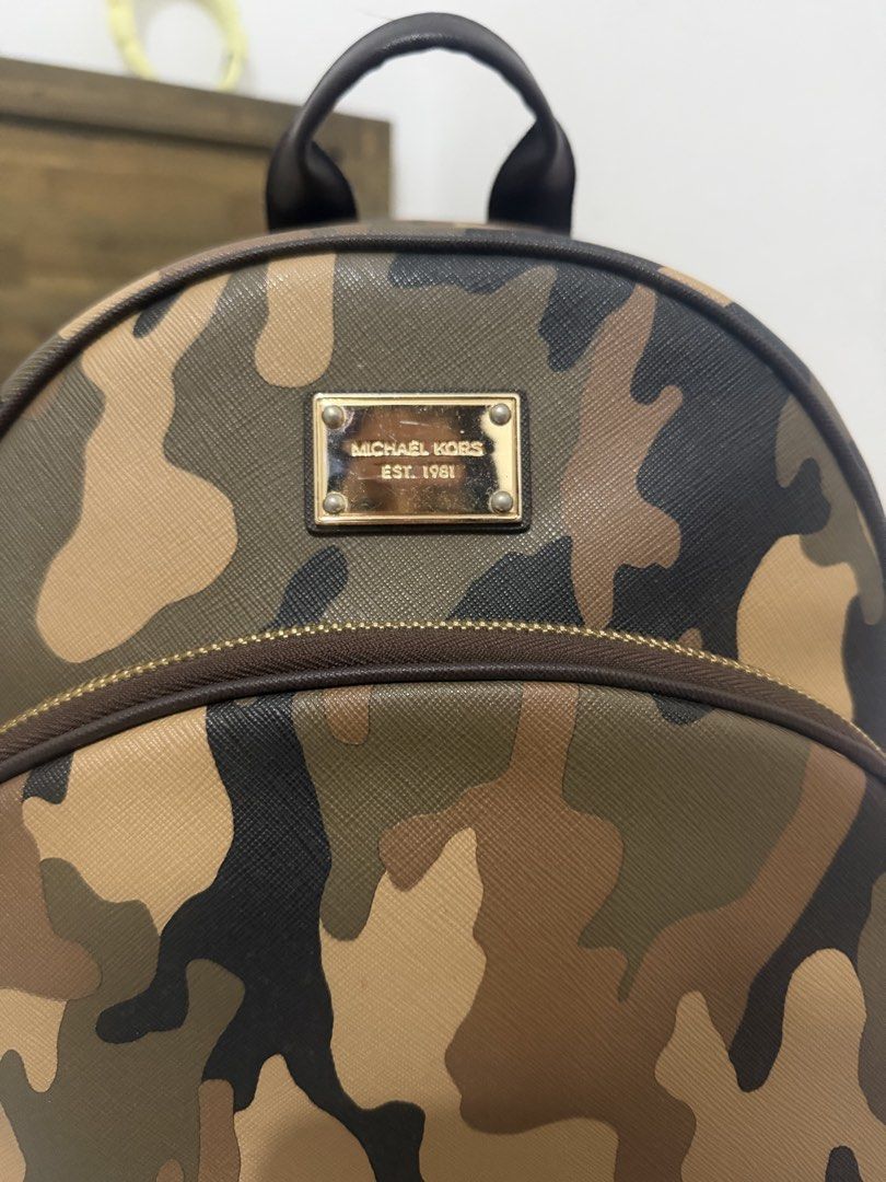 Michael Kors Camouflage Backpack (Category: Backpacks) located in Manila. Submitted by maambeeeeyah (Listing ID 1468175453, Image 2). Description: - Brand: Michael Kors - Design: Classic camouflage print with gold-tone hardware and front logo plaque - Material: Durable, textured Saffiano leather - Storage: Main compartment with plenty of room for essentials plus a front zip pocket for easy access - Comfort: Adjustable beige shoulder straps and to