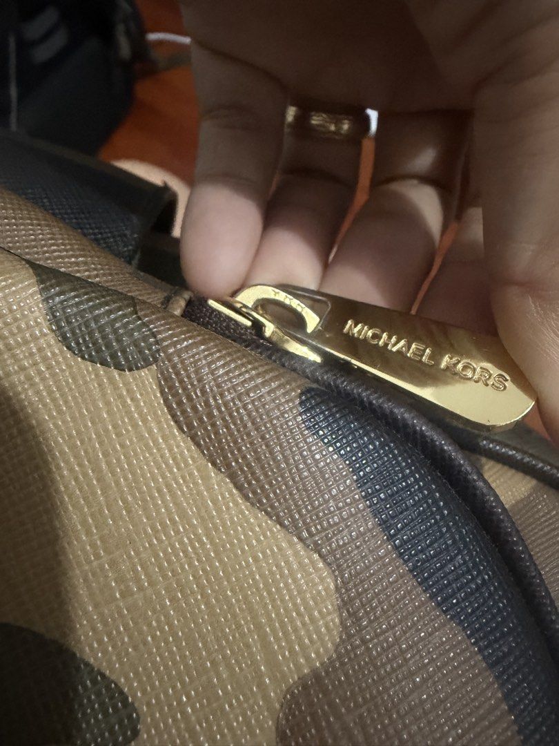 Michael Kors Camouflage Backpack (Category: Backpacks) located in Manila. Submitted by maambeeeeyah (Listing ID 1468175453, Image 3). Description: - Brand: Michael Kors - Design: Classic camouflage print with gold-tone hardware and front logo plaque - Material: Durable, textured Saffiano leather - Storage: Main compartment with plenty of room for essentials plus a front zip pocket for easy access - Comfort: Adjustable beige shoulder straps and to