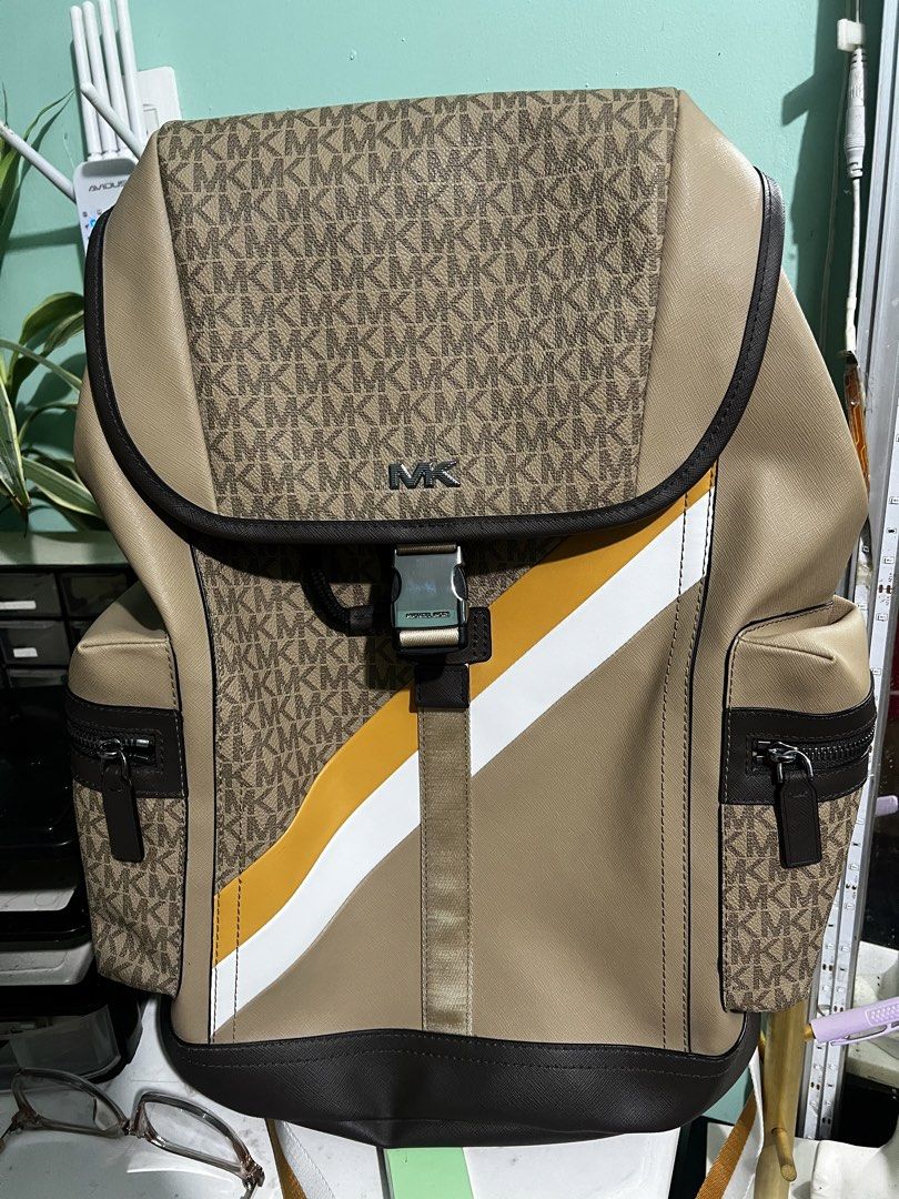 Michael Kors Signature Logo Stripe Flap Backpack (Category: Luxury Bags & Wallets) located in Manila. Submitted by cleverstone_21f597 (Listing ID 1468282302, Image 2). Description: - Authentic Michael Kors backpack in tan and brown monogram - Eye-catching diagonal yellow and white stripe across the front - Flap closure with a stylish buckle accent - Convenient side zip pockets for easy access - Adjustable shoulder straps with a breathable padded 