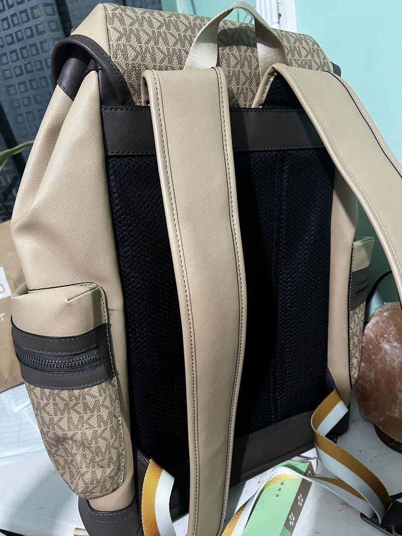 Michael Kors Signature Logo Stripe Flap Backpack (Category: Luxury Bags & Wallets) located in Manila. Submitted by cleverstone_21f597 (Listing ID 1468282302, Image 3). Description: - Authentic Michael Kors backpack in tan and brown monogram - Eye-catching diagonal yellow and white stripe across the front - Flap closure with a stylish buckle accent - Convenient side zip pockets for easy access - Adjustable shoulder straps with a breathable padded 