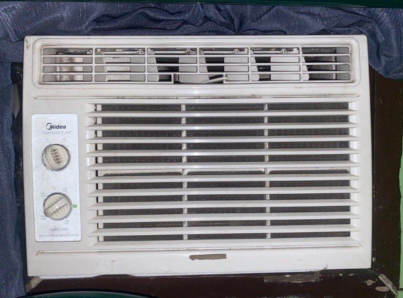 Midea Window Air Conditioner Unit (Category: Air Conditioning and Heating) located in Manila. Submitted by silverriver_d74f1e (Listing ID 1468270295, Image 1). Description: - Brand: Midea - Type: Window type air conditioner - Color: White - Controls: Manual dual rotary knobs for temperature and cooling speed - Features: Horizontal louver vents and top grill for airflow - Condition: Used, with minor dust and scuffs - RFS: Decluttering / No longer 