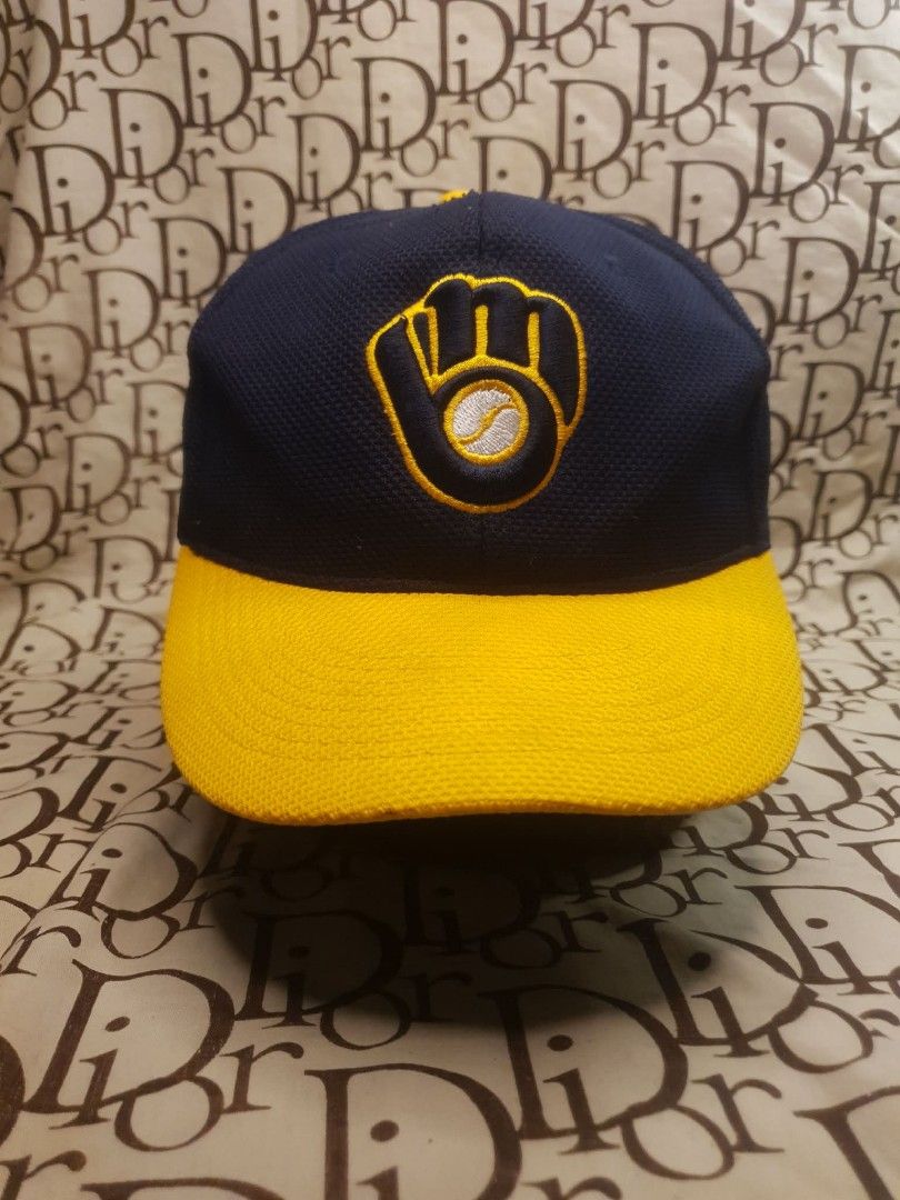 MILWAUKEE BREWERS BASEBALL CAP (Category: Caps & Hats) located in San Fernando. Submitted by _jaximus (Listing ID 1468216969, Image 1). Description: Milwaukee Brewers baseball cap. Navy blue body with a yellow brim and textured mesh fabric. Classic embroidered glove logo on the front. Small KTI Country embroidery on the side panel. Blue plastic snapback closure on the back for adjustable sizing. Interior shows visible sweat stains along the inner