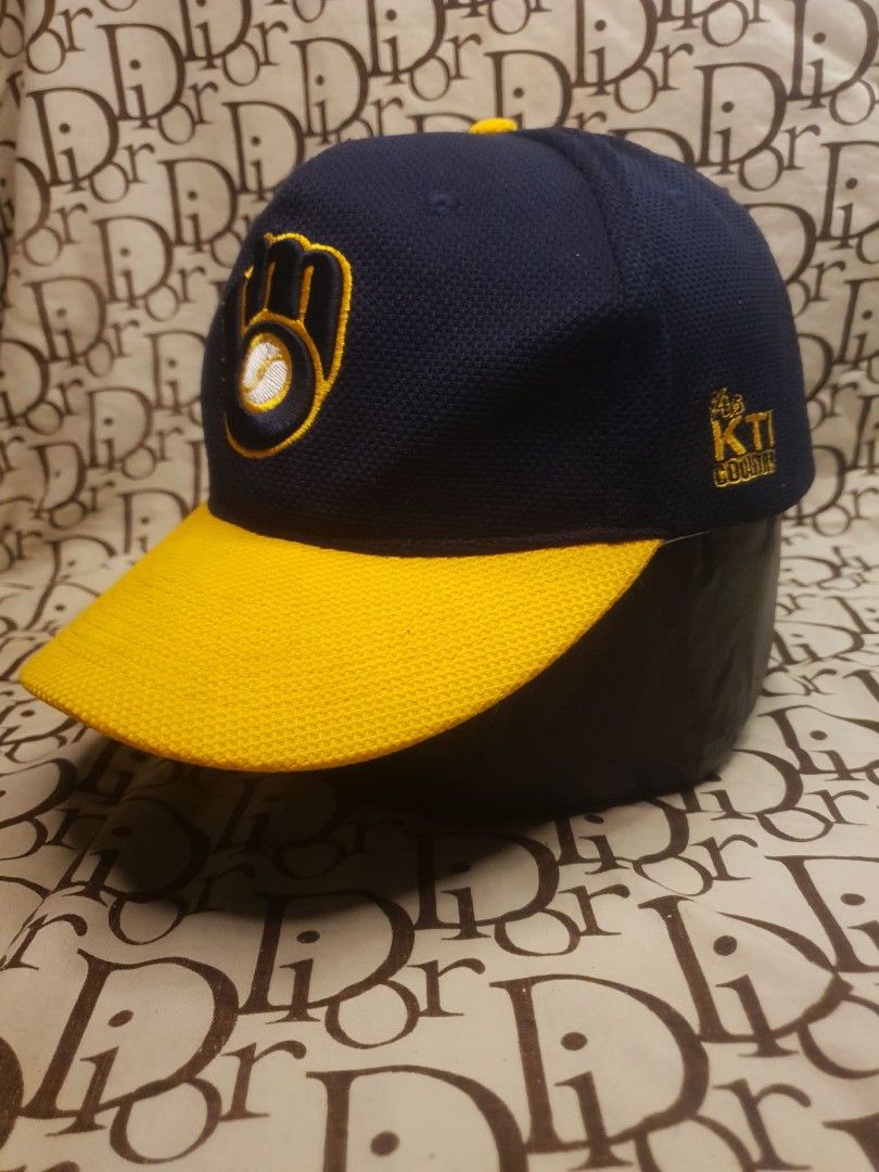 MILWAUKEE BREWERS BASEBALL CAP (Category: Caps & Hats) located in San Fernando. Submitted by _jaximus (Listing ID 1468216969, Image 3). Description: Milwaukee Brewers baseball cap. Navy blue body with a yellow brim and textured mesh fabric. Classic embroidered glove logo on the front. Small KTI Country embroidery on the side panel. Blue plastic snapback closure on the back for adjustable sizing. Interior shows visible sweat stains along the inner