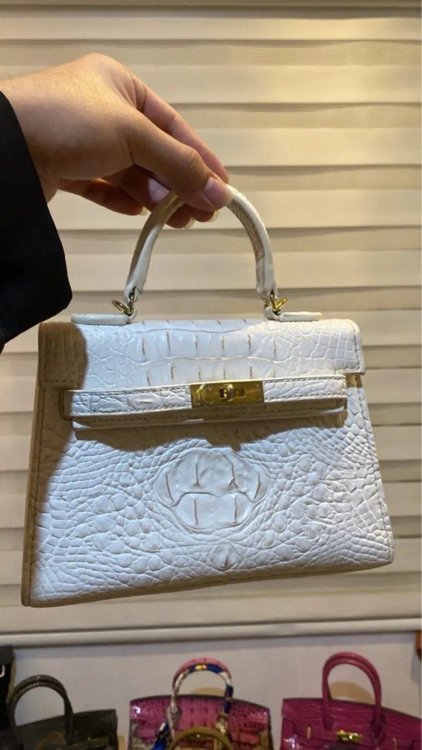 Mini Kelly-Ins 22 White Croc (Category: Luxury Bags & Wallets) located in Manila. Submitted by wandathescarletwitch (Listing ID 1468059729, Image 3). Description: - Color & Texture: White crocodile-embossed leather - Design: Mini structured shape with clean stitching - Hardware: Gold-tone front flap closure and ring attachments for the top handle - Base: Flat bottom panel with protective metal feet - Style: Compact and versatile for daily styling