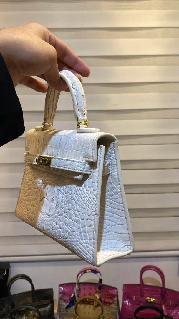 Mini Kelly-Ins 22 White Croc (Category: Luxury Bags & Wallets) located in Manila. Submitted by wandathescarletwitch (Listing ID 1468059729, Image 2). Description: - Color & Texture: White crocodile-embossed leather - Design: Mini structured shape with clean stitching - Hardware: Gold-tone front flap closure and ring attachments for the top handle - Base: Flat bottom panel with protective metal feet - Style: Compact and versatile for daily styling