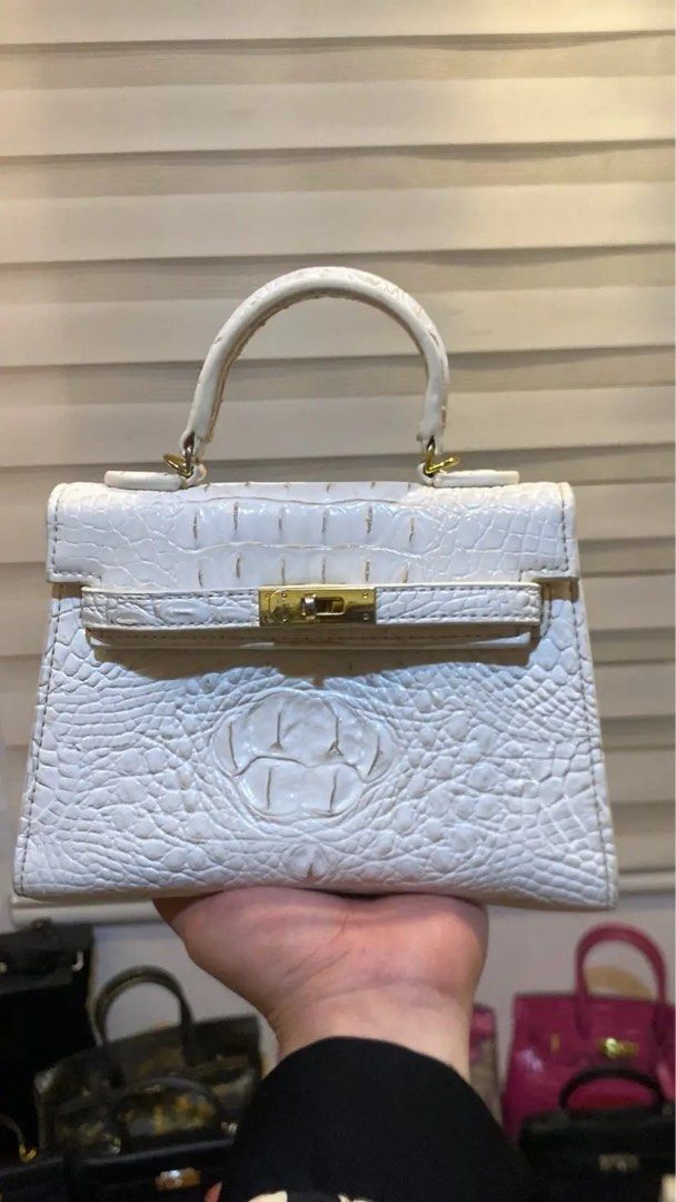Mini Kelly-Ins 22 White Croc (Category: Luxury Bags & Wallets) located in Manila. Submitted by wandathescarletwitch (Listing ID 1468059729, Image 1). Description: - Color & Texture: White crocodile-embossed leather - Design: Mini structured shape with clean stitching - Hardware: Gold-tone front flap closure and ring attachments for the top handle - Base: Flat bottom panel with protective metal feet - Style: Compact and versatile for daily styling