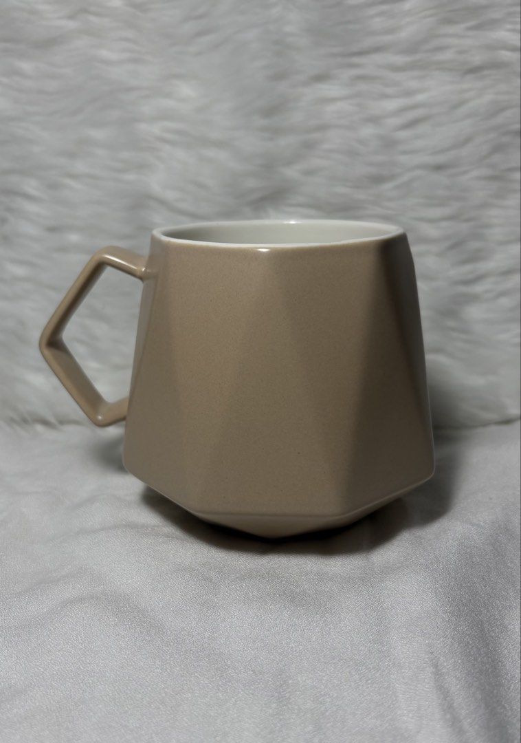 Minimalist Matte Taupe Geometric Ceramic Mug (Category: Coffee & Tea Tableware) located in Manila. Submitted by mug.aras (Listing ID 1468221567, Image 1). Description: Elevate your coffee or tea rituals with this gorgeous minimalist mug. It features a modern, multi-faceted geometric design in a soothing matte taupe/nude color, paired with a matching angular handle. Perfect for minimalist home aesthetics, Nordic-inspired kitchens, or desk setups!.