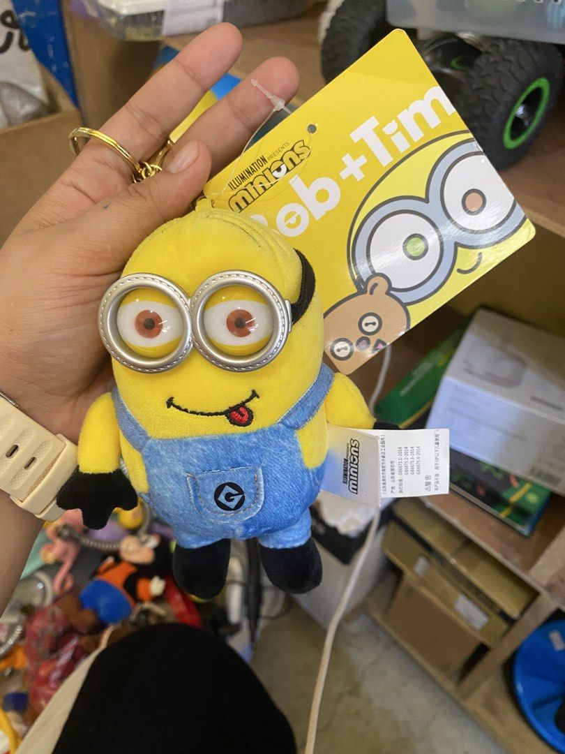 Minions Bob + Tim Plush Keychain (Category: Plushies & Soft Toys) located in Baguio. Submitted by thrift_bonita (Listing ID 1468147549, Image 1). Description: - Authentic Illumination Minions plush keychain - Features Bob with a cute sticking-out tongue and Tim bear tag - Wears blue denim-style overalls with the 'G' logo pocket - Detailed with black gloves, boots, and plastic goggles - Includes a sturdy gold-tone keyring - Brand new with original