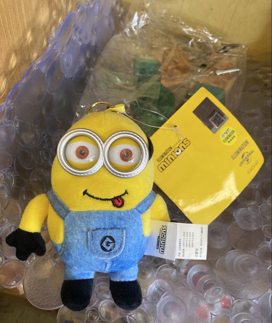 Minions Bob + Tim Plush Keychain (Category: Plushies & Soft Toys) located in Baguio. Submitted by thrift_bonita (Listing ID 1468147549, Image 3). Description: - Authentic Illumination Minions plush keychain - Features Bob with a cute sticking-out tongue and Tim bear tag - Wears blue denim-style overalls with the 'G' logo pocket - Detailed with black gloves, boots, and plastic goggles - Includes a sturdy gold-tone keyring - Brand new with original