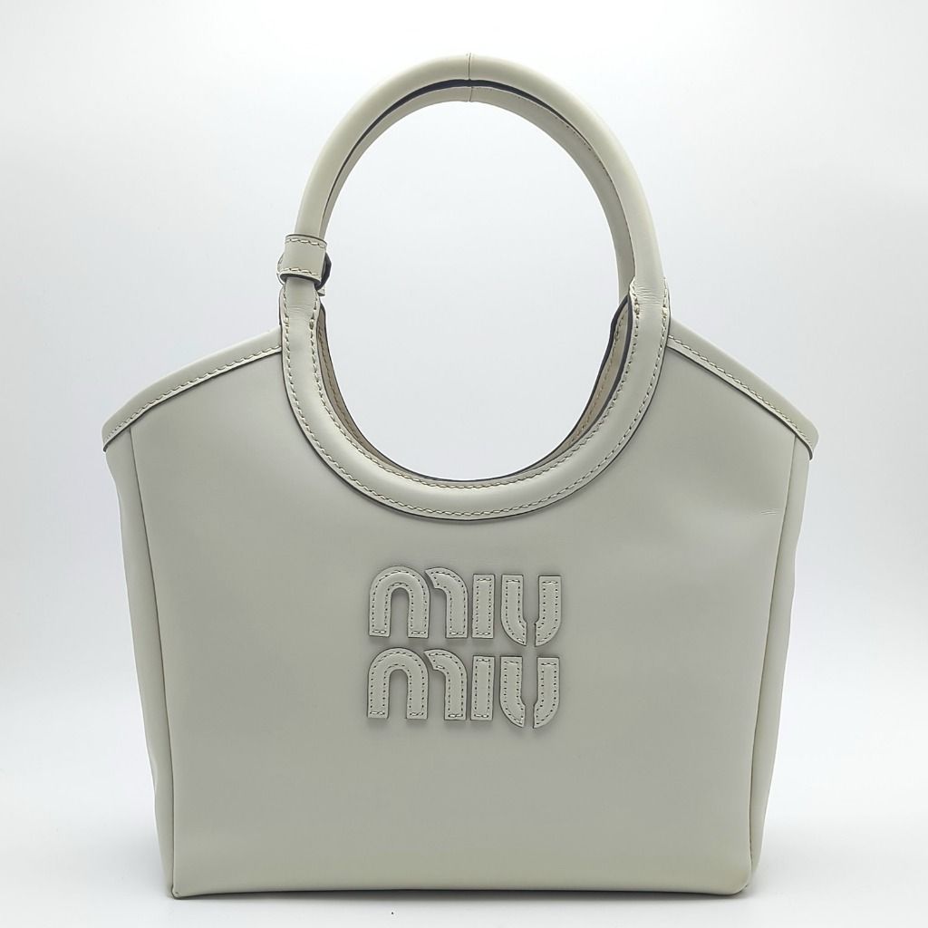 Miu Miu Ivy Top Handle Bag Off White (Category: Luxury Bags & Wallets) located in Cebu City. Submitted by affordabagss (Listing ID 1468100597, Image 1). Description: Miu Miu Ivy top handle bag crafted in smooth calfskin leather in a soft off-white shade with gold-tone hardware. Features the signature raised Miu Miu lettering logo, rounded leather top handles, and detachable adjustable leather shoulder strap. Finished with a structured tote-inspir
