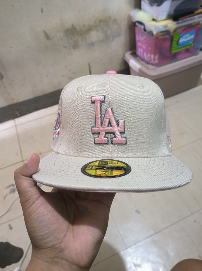 New Era LA Dodgers 59FIFTY Fitted Cap (Category: Caps & Hats) located in Manila. Submitted by joshleyy (Listing ID 1468062988, Image 1). Description: - Brand: New Era 59FIFTY LA Dodgers Fitted Cap - Size: 7 (55.8cm) - Colorway: Cream body with pink LA front logo and matching top button - Special Details: Floral embroidery side patch with D motif and pink underbrim - Structure: High crown with flat visor and original gold size sticker - Condition: