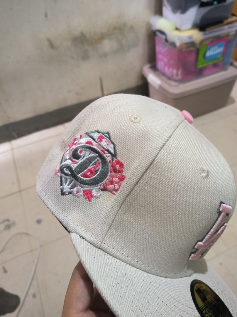 New Era LA Dodgers 59FIFTY Fitted Cap (Category: Caps & Hats) located in Manila. Submitted by joshleyy (Listing ID 1468062988, Image 3). Description: - Brand: New Era 59FIFTY LA Dodgers Fitted Cap - Size: 7 (55.8cm) - Colorway: Cream body with pink LA front logo and matching top button - Special Details: Floral embroidery side patch with D motif and pink underbrim - Structure: High crown with flat visor and original gold size sticker - Condition: